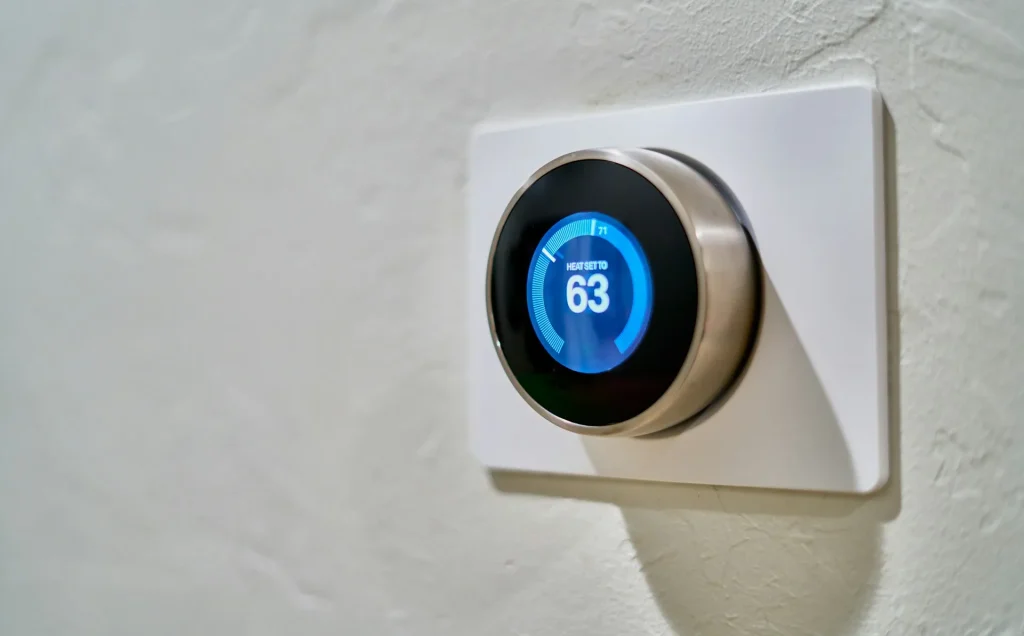 Smartphone yang mengontrol perangkat IoT di sebuah kamar hostel.